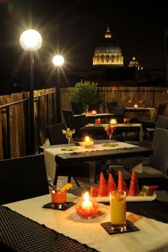 a restaurant with tables and candles on a patio at night at Hotel Gravina San Pietro in Rome