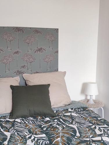 - une chambre avec un lit doté d'une tête de lit à motifs dans l'établissement Maison de charme avec jacuzzi, à Saint-Étienne