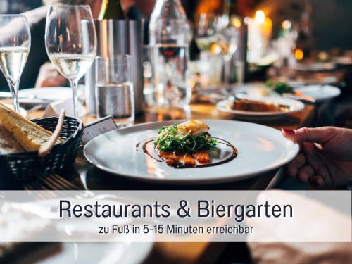 a table with plates of food and glasses of wine at Ferienhaus Bauer in Piding in Piding