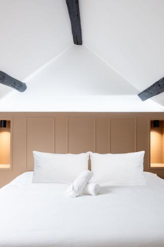 un lit blanc avec un ours en peluche assis sur lui dans l'établissement Le Masterbedroom - 4 pers - Nouveau - Disney, à Montry