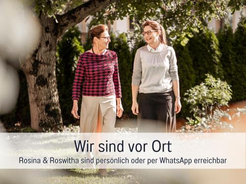 two women standing next to each other on a sidewalk at Ferienhaus Bauer in Piding in Piding