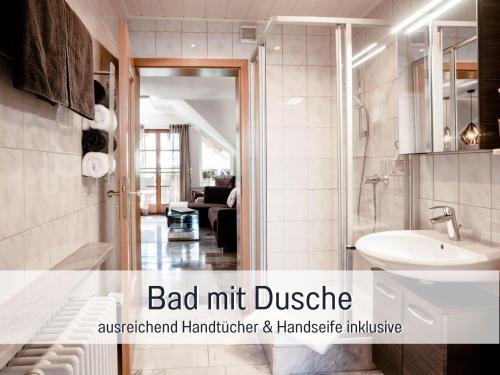 a bathroom with a white sink and a couch at Ferienhaus Bauer in Piding in Piding