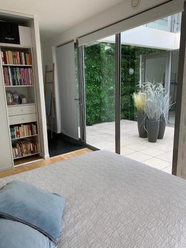 シュレーヌにあるChambres dans maison d'architecteのベッドルーム1室(ベッド1台付)、スライド式ガラスドアが備わります。