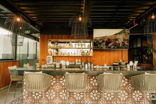 a restaurant with a bar with wicker chairs at IT Boutique Hotel & Restaurant in Playa del Carmen