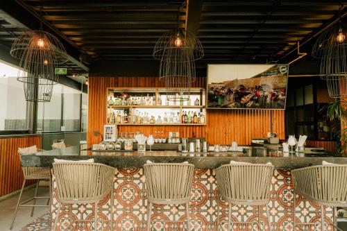 a restaurant with a bar with wicker chairs at IT Boutique Hotel & Restaurant in Playa del Carmen