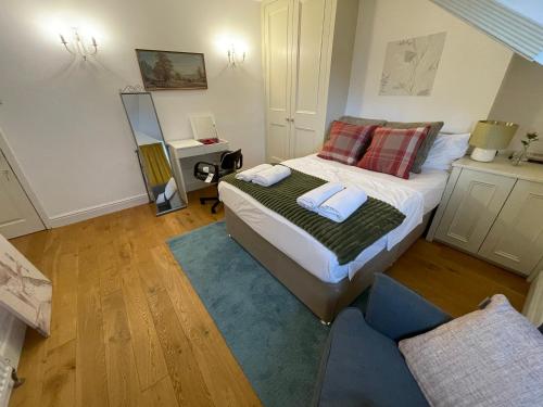 um pequeno quarto com uma cama e um sofá em Luxury Ensuite Rooms in Surbiton, An easy acess to central London em Surbiton