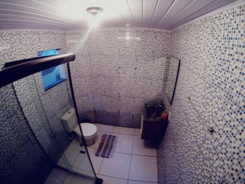 a bathroom with a white toilet and a light at Casa do Aventureiro Holiday Home in Abraão