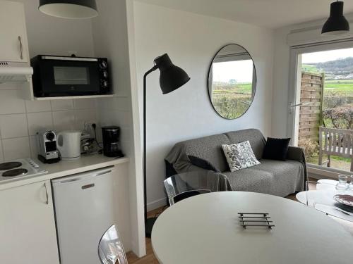 uma cozinha e uma sala de estar com um sofá e uma mesa em Coquillages et crustacés em Criel-sur-Mer