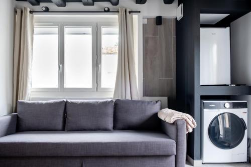 a living room with a couch and a washing machine at Le Bel Air - 6 pers - logement neuf proche Disney in Montry