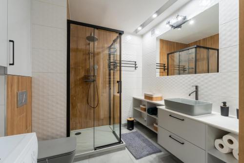 a bathroom with a glass shower and a sink at Apartament przy Baszcie - z prywatnym parkingiem w centrum - by SpaceApart in Jelenia Góra