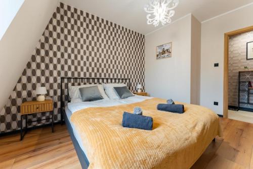 a bedroom with a large bed with two blue towels on it at Apartament przy Baszcie - z prywatnym parkingiem w centrum - by SpaceApart in Jelenia Góra