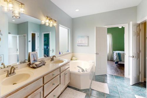 a bathroom with two sinks and a tub and a toilet at Shore Beats Work in Dauphin Island