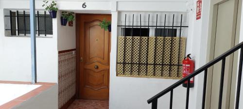 a hallway with a wooden door and a fire extinguisher at Casa Conchi Córdoba in Córdoba