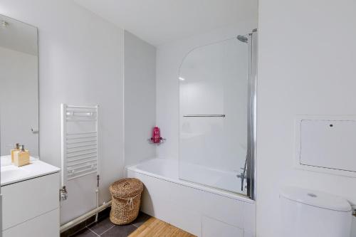 une salle de bain blanche avec une douche et un lavabo dans l'établissement Charmant 2 pièces avec Terrasse Proche Transport, à Épinay-sur-Seine