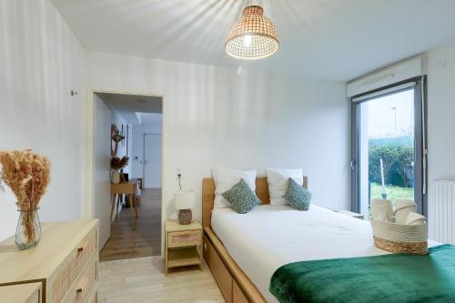 une chambre avec un grand lit blanc avec une fenêtre dans l'établissement Charmant 2 pièces avec Terrasse Proche Transport, à Épinay-sur-Seine