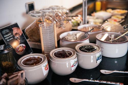 a counter top with several pots of food at Hotel Goldene Rose in Monguelfo