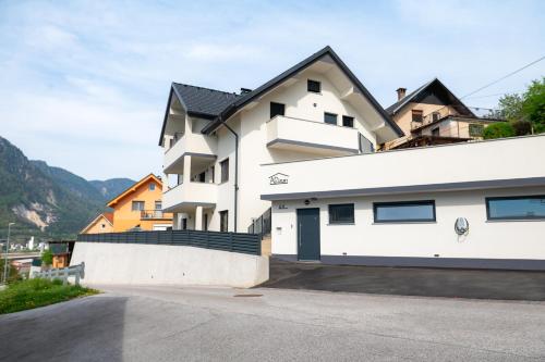 a white house with a black roof at Apartments Luxury AD in Jesenice
