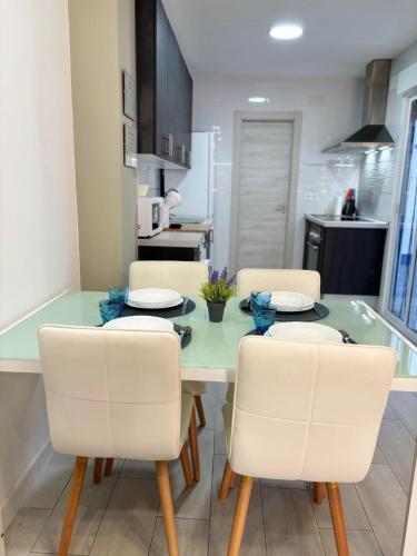 a kitchen with a table with white chairs and a kitchen with a kitchen at Apartamento Sofía I a 500m de la Playa con Parking solo para motos y bicicletas in Puerto de Sagunto