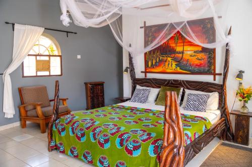 1 dormitorio con 1 cama y una pintura en la pared en Afro Garden Hotel en Sere Kunda