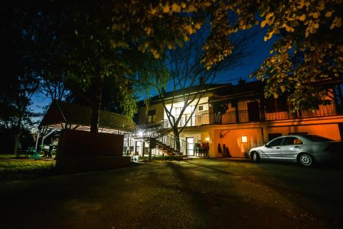 un coche aparcado delante de una casa por la noche en Banat Terra Biserno Ostrvo en Novi Bečej