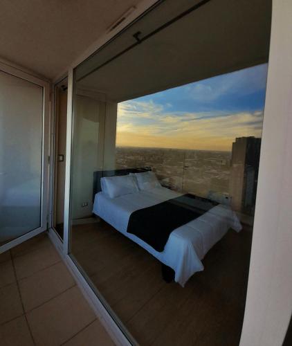 a bedroom with a large window with a bed at Tu hogar lejos de casa in Chillán
