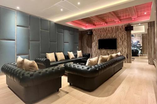 a living room with two leather couches and a television at Aquarius Motel in Taichung