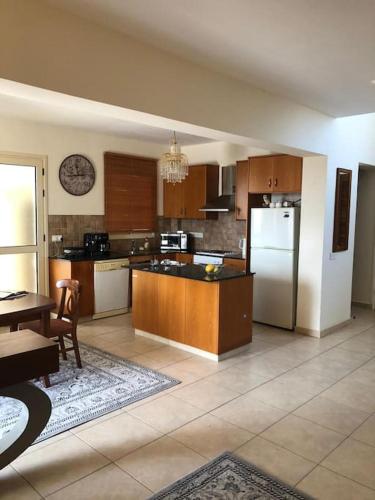 a large kitchen with wooden cabinets and a refrigerator at Budget Escape to the seaside in Larnaca