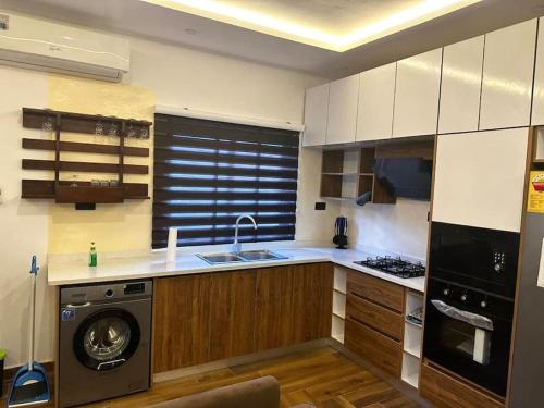 a kitchen with a washer and a dishwasher at Fully Furnished 1 Bedroom House in Accra