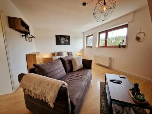 a living room with a couch and a table at Fewo NATURgeTREU in Medebach