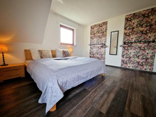 a bedroom with a large bed and a window at Fewo NATURgeTREU in Medebach