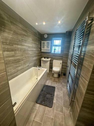 a bathroom with a tub and a toilet and a sink at Your Stylish Totterdown Haven in Bristol
