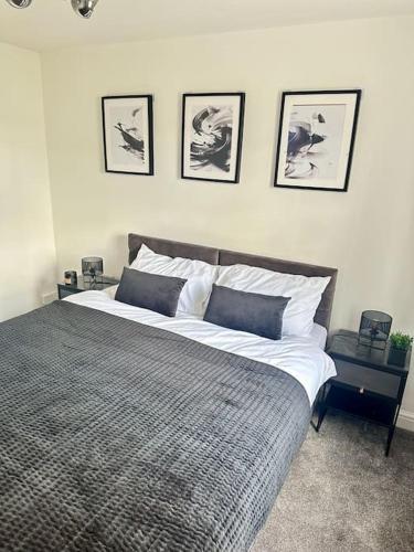 a bedroom with a large bed with four pictures on the wall at Your Stylish Totterdown Haven in Bristol