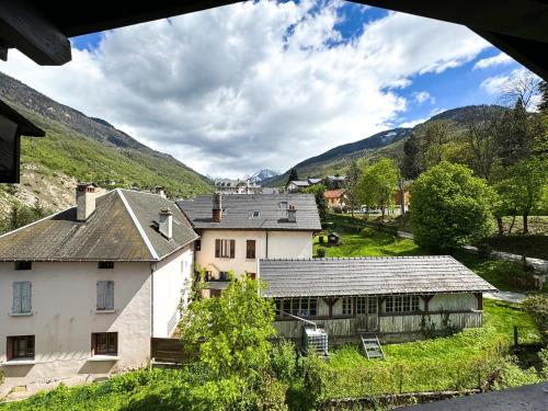 ein großes weißes Haus mit Bergen im Hintergrund in der Unterkunft 4- Joli studio Brides-les-Bains avec vue montagne in Brides-les-Bains