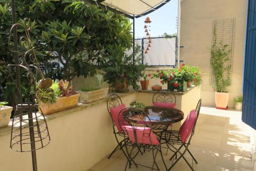 a patio with a table and chairs and plants at tombe la nèfle in Avignon
