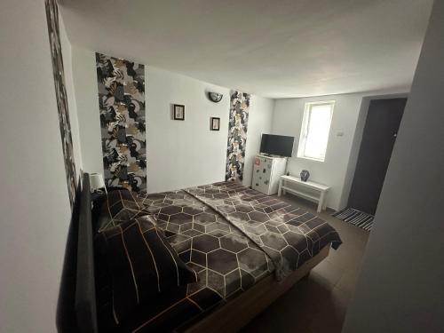 a bedroom with a bed with a brown comforter at Camere de Închiriat David Corbu in Corbu