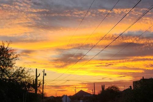 a sunset in the sky with power lines at Western Tinyhouse, Ready For Summer Fun! in Apache Junction