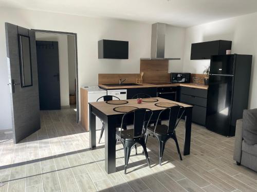 une cuisine avec une table et des chaises dans une pièce dans l'établissement Maison de 40m2 avec jardin de 50m2, à Orange