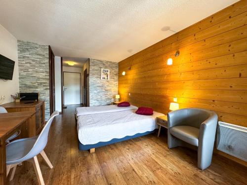 een slaapkamer met een bed, een bureau en stoelen bij 5- Brides-les-Bains Studio de charme avec vue montagne in Brides-les-Bains