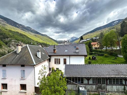 een wit huis met bergen op de achtergrond bij 5- Brides-les-Bains Studio de charme avec vue montagne in Brides-les-Bains