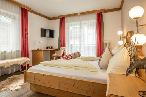 Schlafzimmer mit einem großen Bett und roten Vorhängen in der Unterkunft Mara's Little Boutique Sleepover - Renovated in 2024 in Kaprun