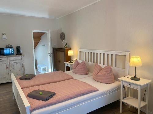 - une chambre avec 2 lits avec des oreillers roses dans l'établissement Gästehaus Kerber, à Merzig