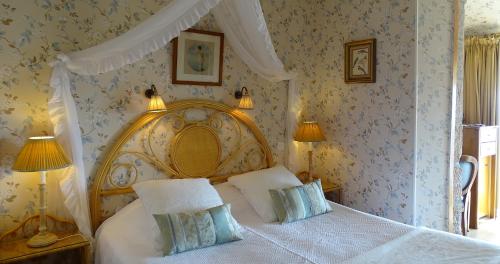 a bedroom with a canopy bed with two pillows at TI AL LANNEC Hotel - Restaurant & Spa in Trébeurden