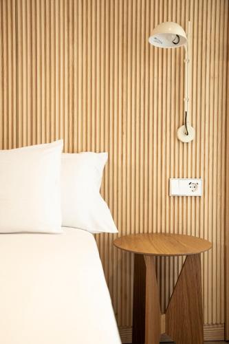 a bedroom with a bed and a table with a lamp at Hotel Dos Rios Origen in Aínsa