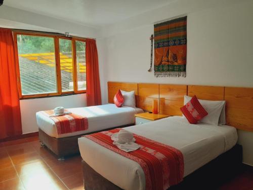 a hotel room with two beds and a window at Fenix Hotel Machupicchu by Bruno's in Machu Picchu