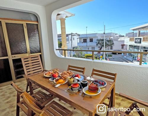 a table with food on it in a room with a window at SeaBreeze - Torre San Giovanni in Torre San Giovanni Ugento
