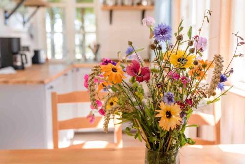 a vase filled with flowers sitting on a table at Erholung gesucht Erholung gebucht 800m zum Meer in Fehmarn