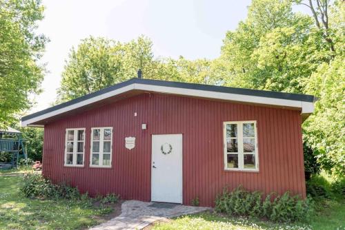 a red shed with a white door at Erholung gesucht Erholung gebucht 800m zum Meer in Fehmarn