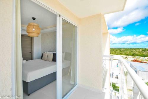 a bedroom with a bed and a balcony with a view at Full CozyCondo+Private Terrace+BBQ in Punta Cana