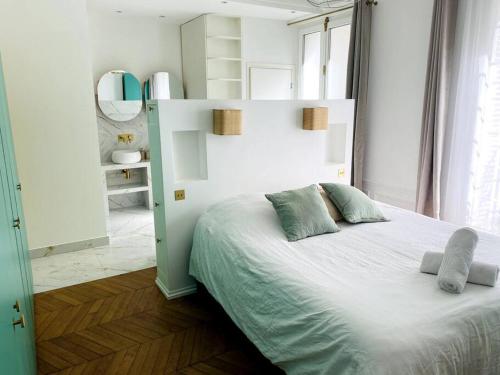 une chambre avec un lit blanc avec deux oreillers dessus dans l'établissement Triplex à Montmartre - Sauna, à Paris