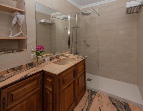 a bathroom with a sink and a shower at Hotel Sablón in Llanes